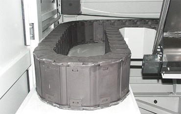 Finies les traces de brûlures : gaine porte-câbles en polymère spécial « igumid HT ».Les copeaux jusqu’à 850°C glissent sur le guidage de l'énergie sans s'incruster.